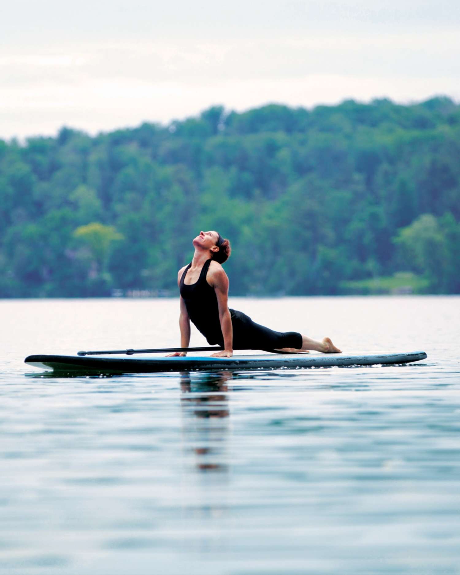 A woman doing paddleboard yoga
