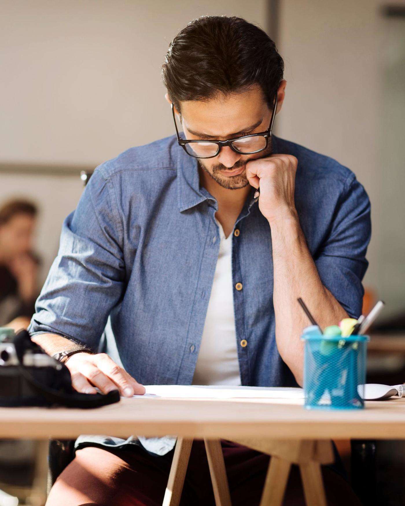A man looking a papers on his desk