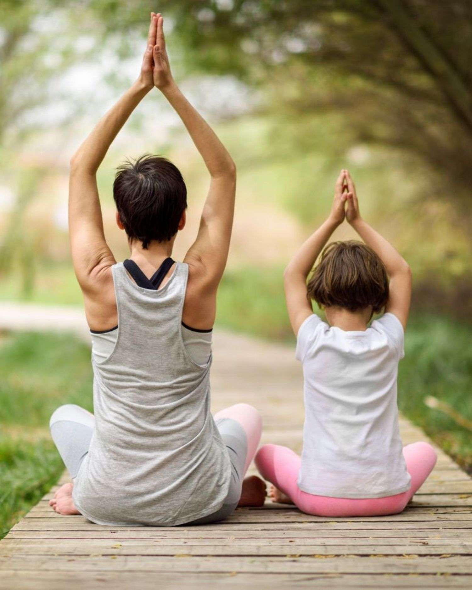 a mom and daughter doing yoga together