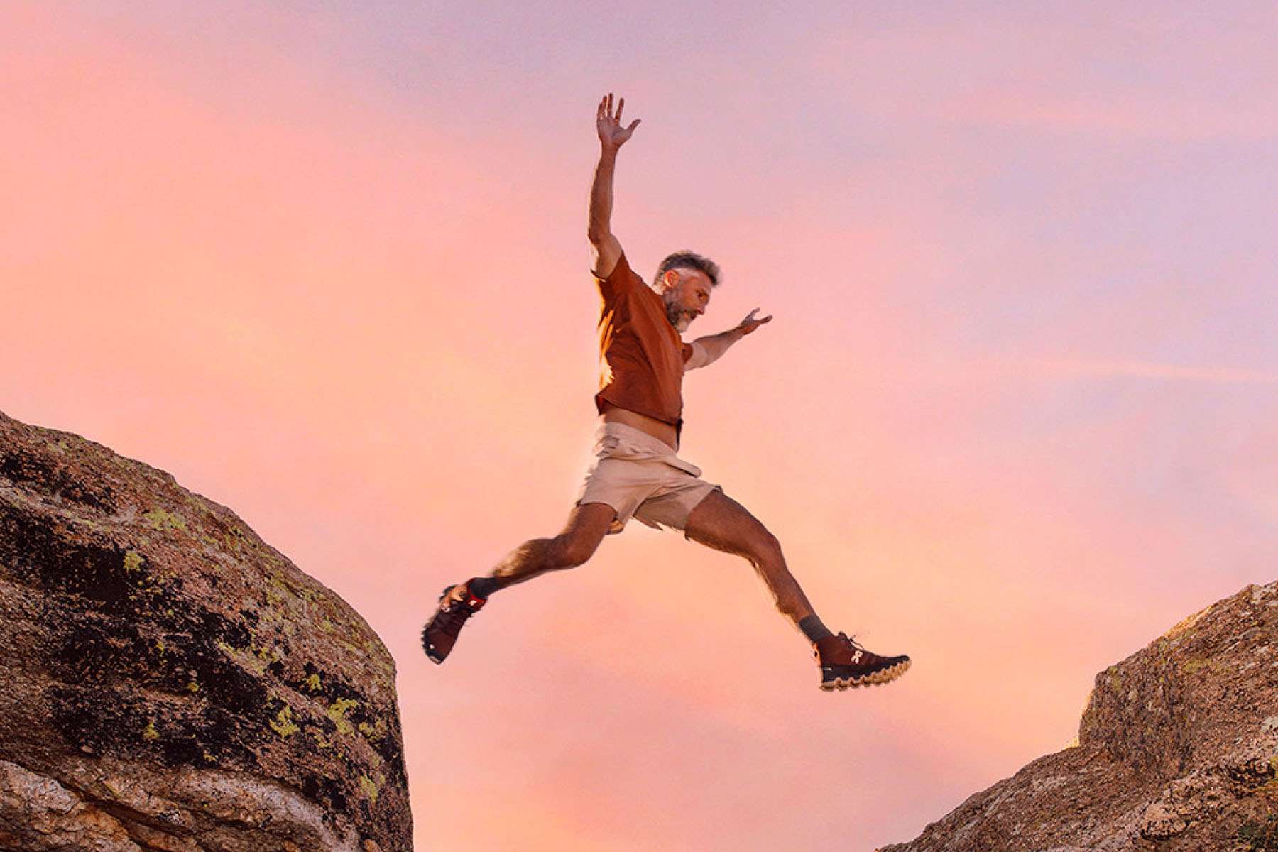 a man jumping over a rock