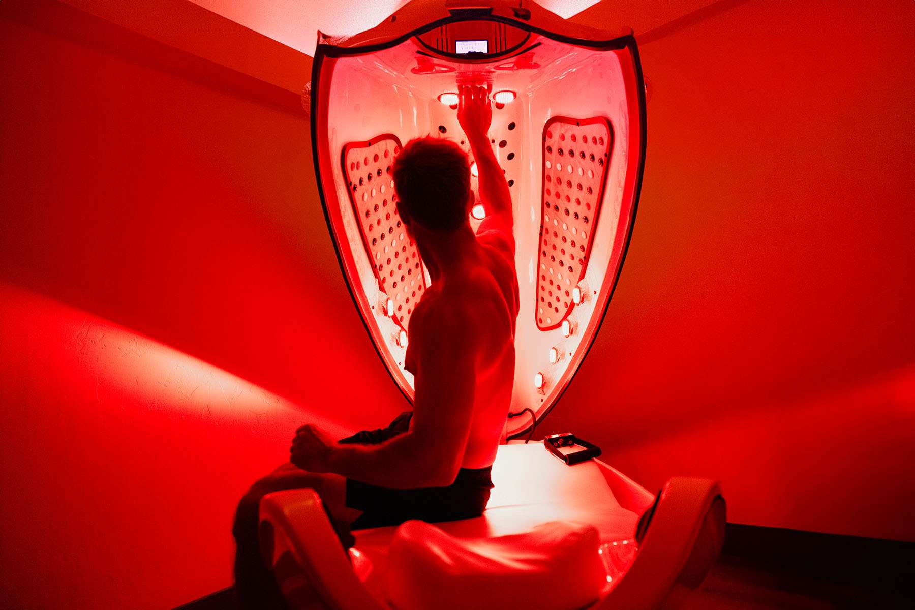 a man in a red light bed