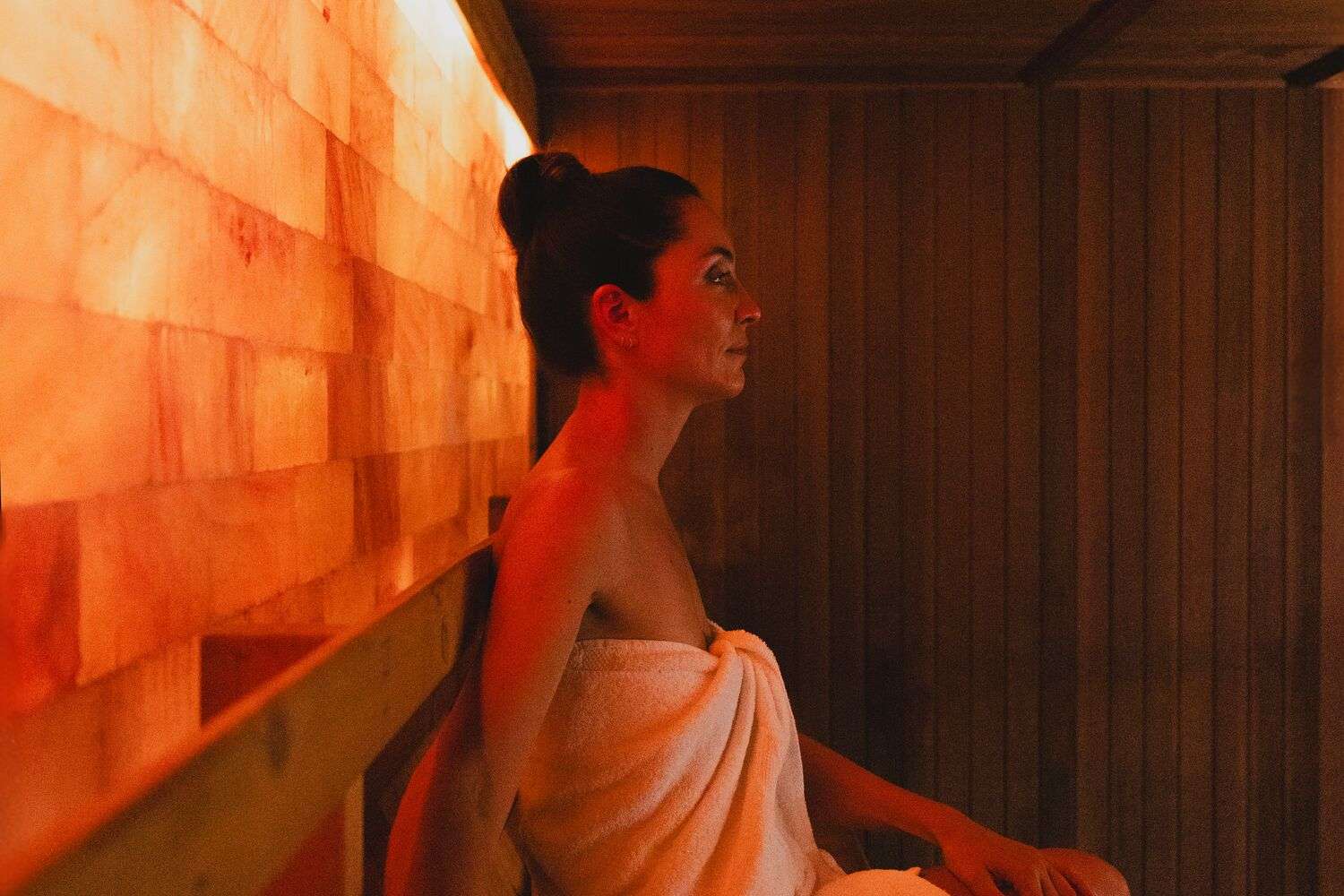 Woman in Towel in Sauna with Salt Wall