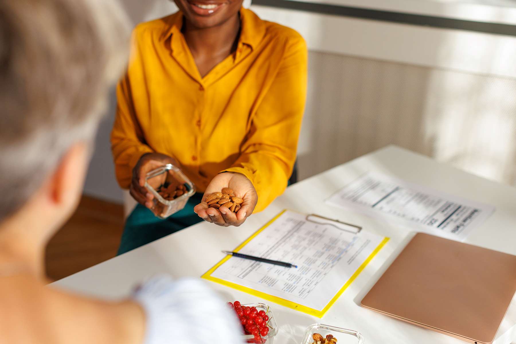 a woman handing nuts to someone off screen