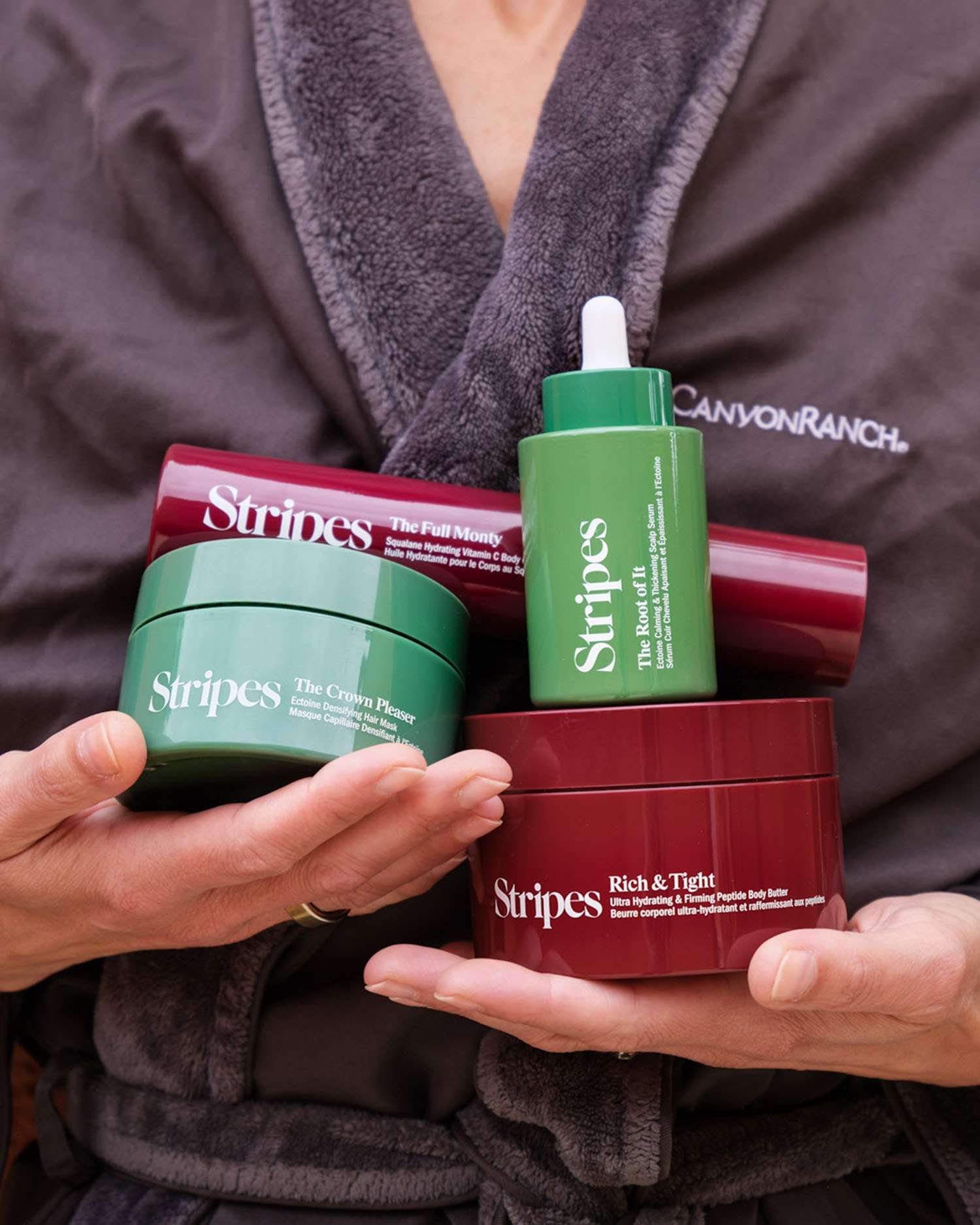 A Woman in Bathrobe Holding Stripes Beauty Products