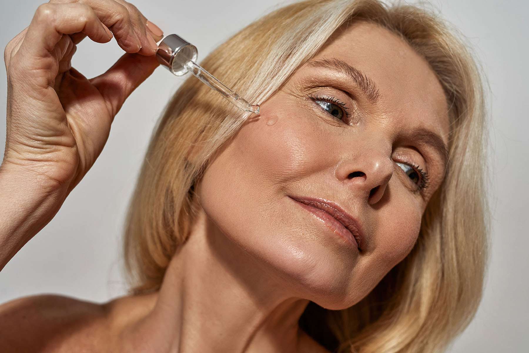 a woman putting skin care products on her face