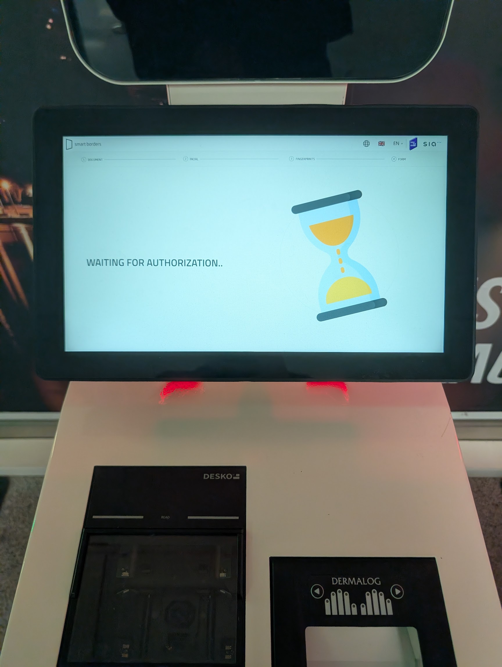 An EES kiosk showing WAITING FOR AUTHORIZATION with an hourglass