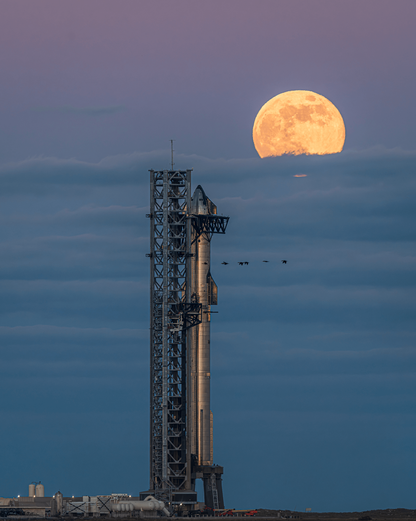 A breathtaking image captures Starship 6 poised on the launch pad, with the moon illuminating the backdrop.