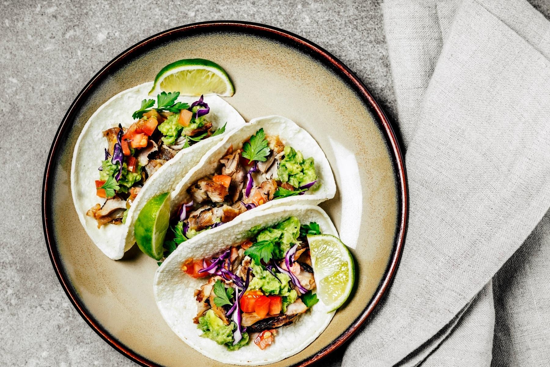 Overhead view of chicken tacos on plate.