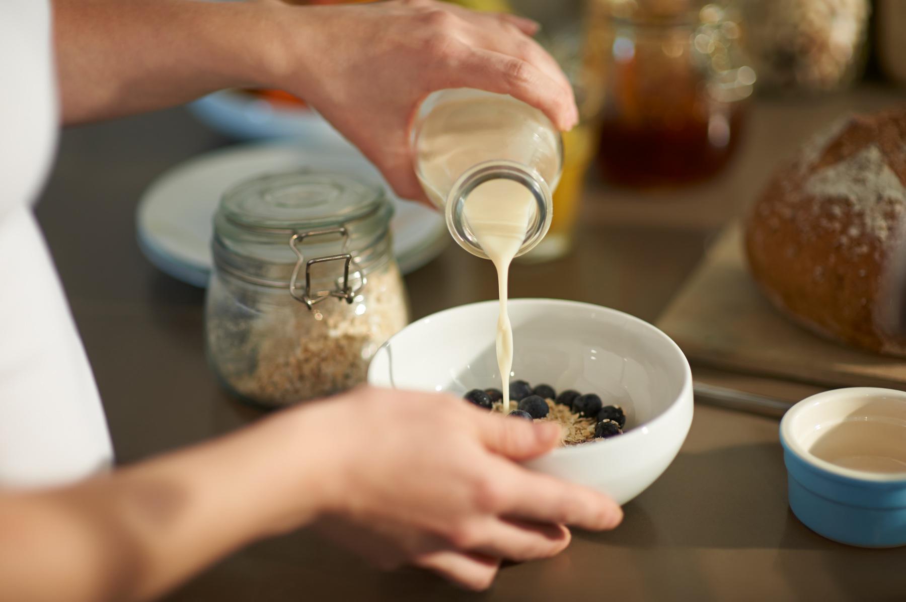 pouring milk into bowl of cereal