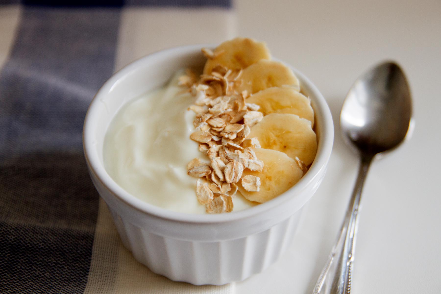 close-up of bowl of yogurt with banana and granola on top