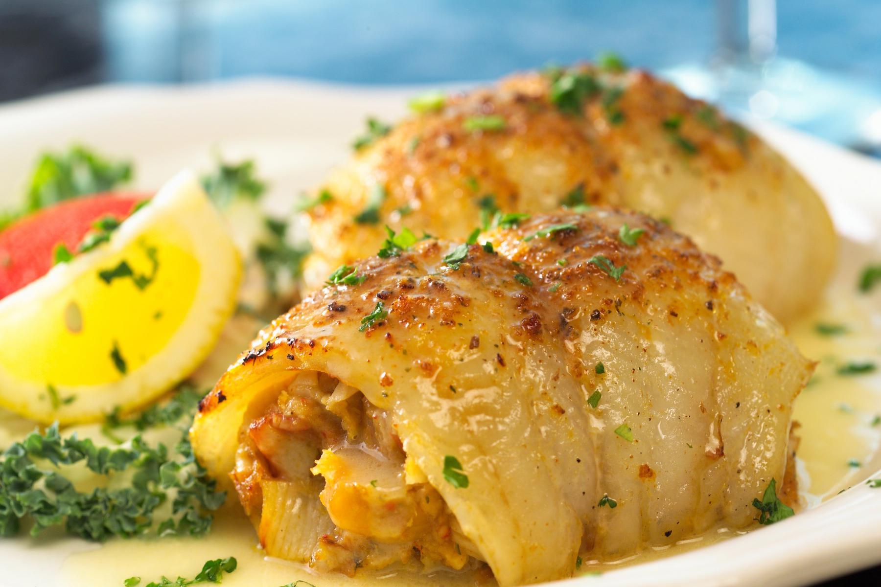Close-up of sole Florentine on plate next to lemon slice.