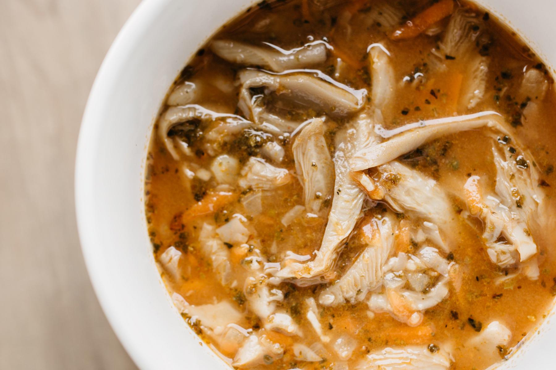 Overhead view of a bowl of oyster mushroom soup.