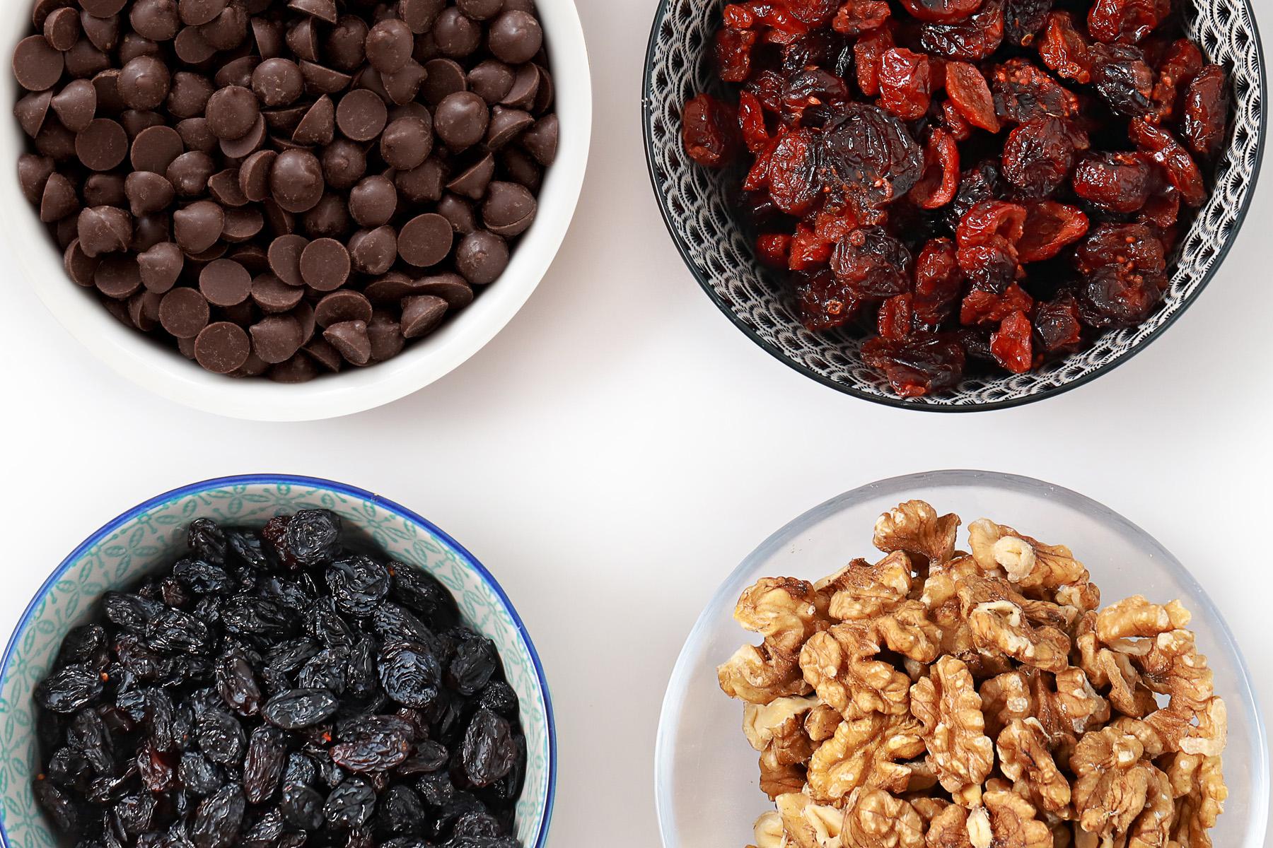 Overhead view of trail mix ingredients in small bowls.