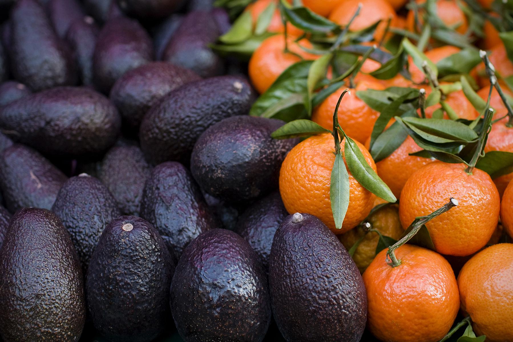 Close up of avocados and oranges.
