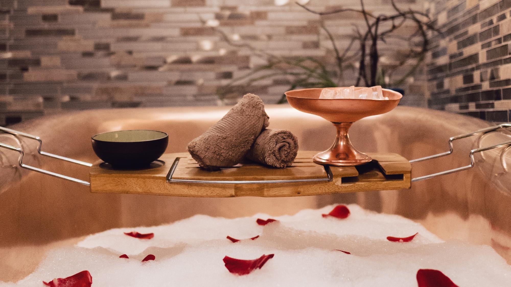 Bathtub with bubbles and rose petals