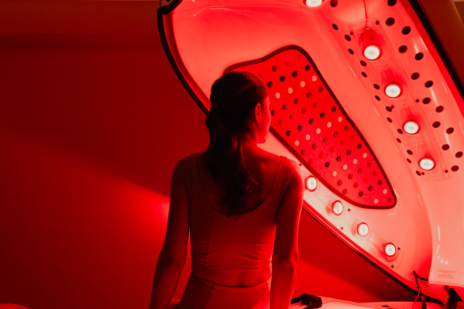 A man in a read light therapy bed