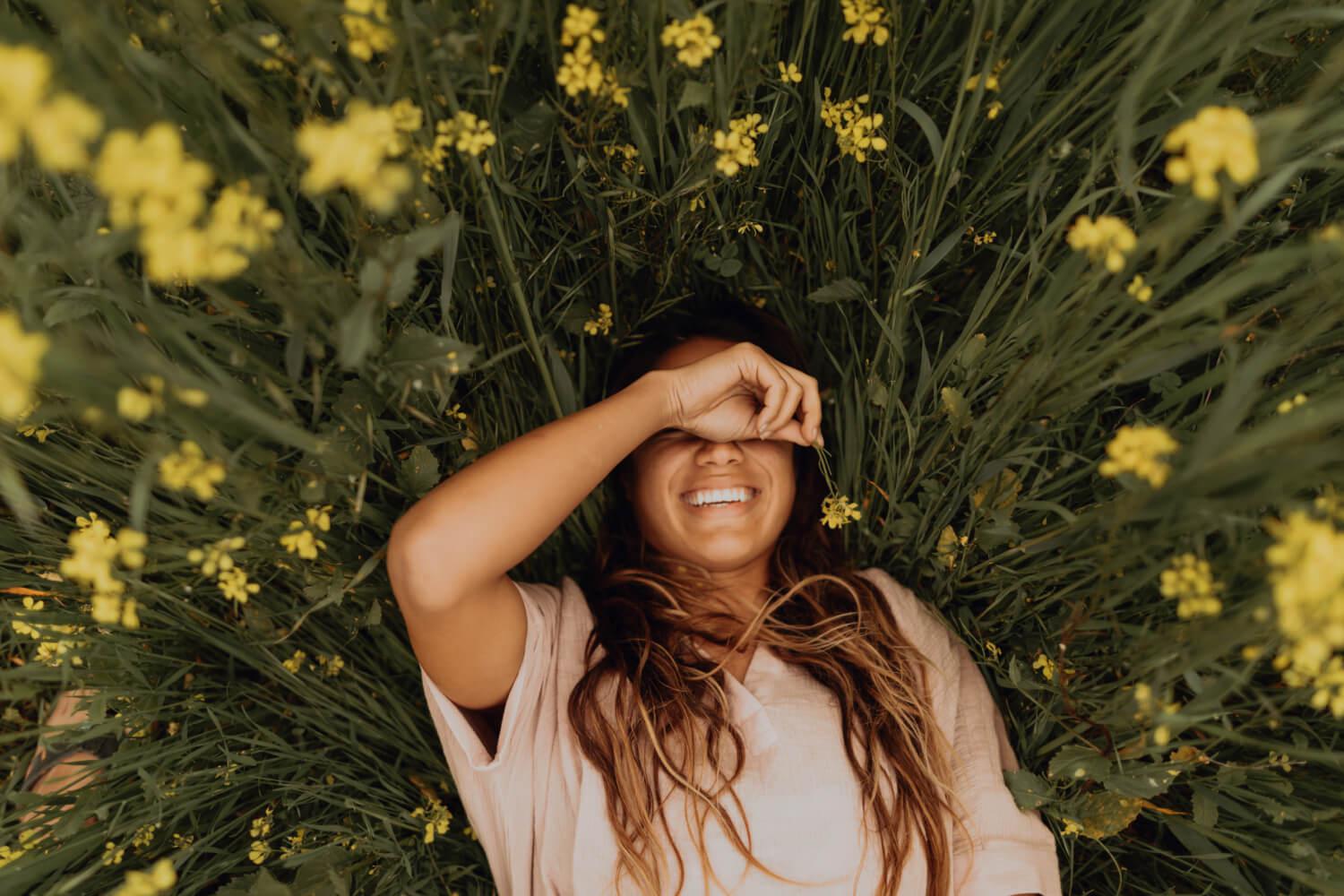 a woman laying in a field of flowers