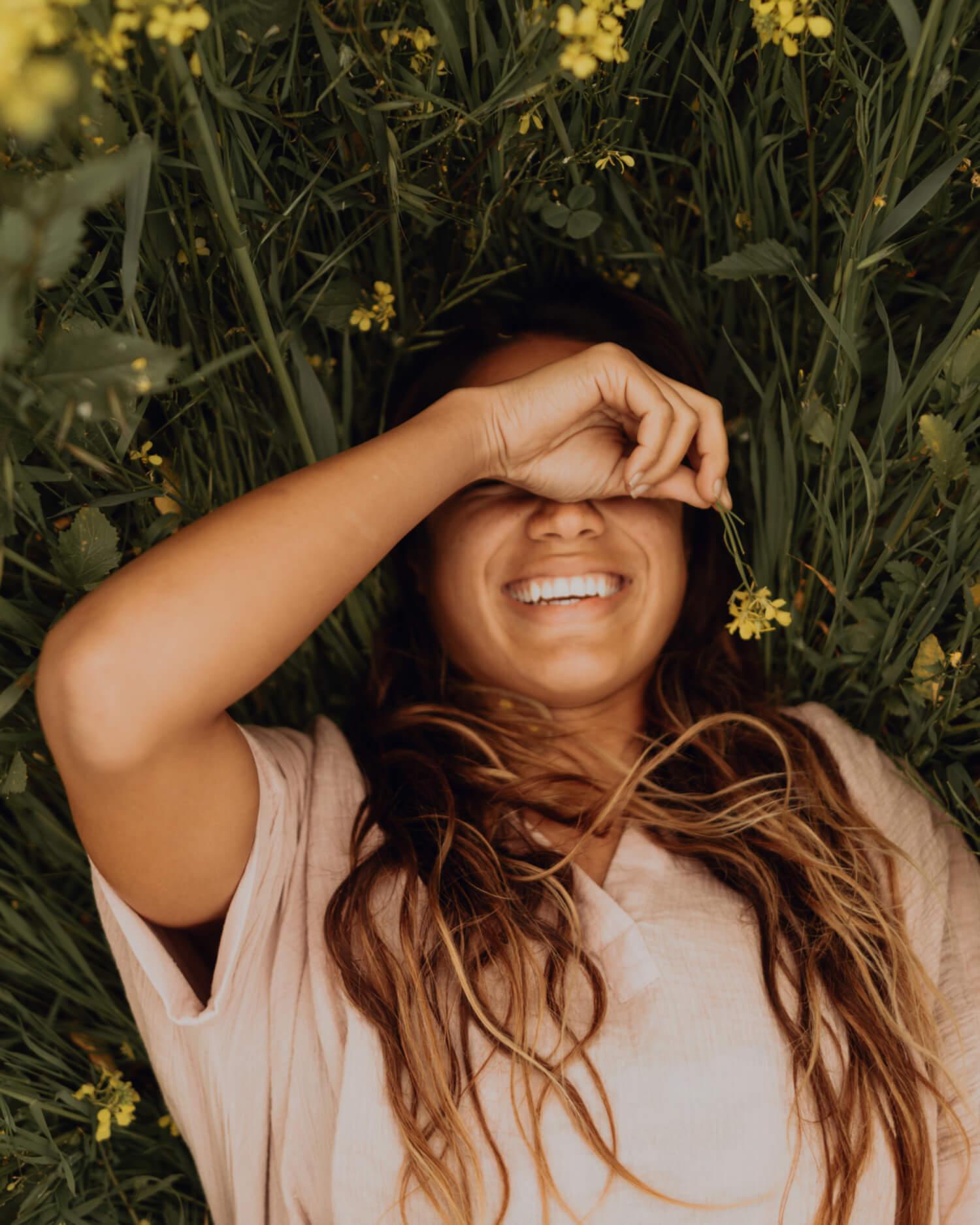 a woman laying in a field of flowers