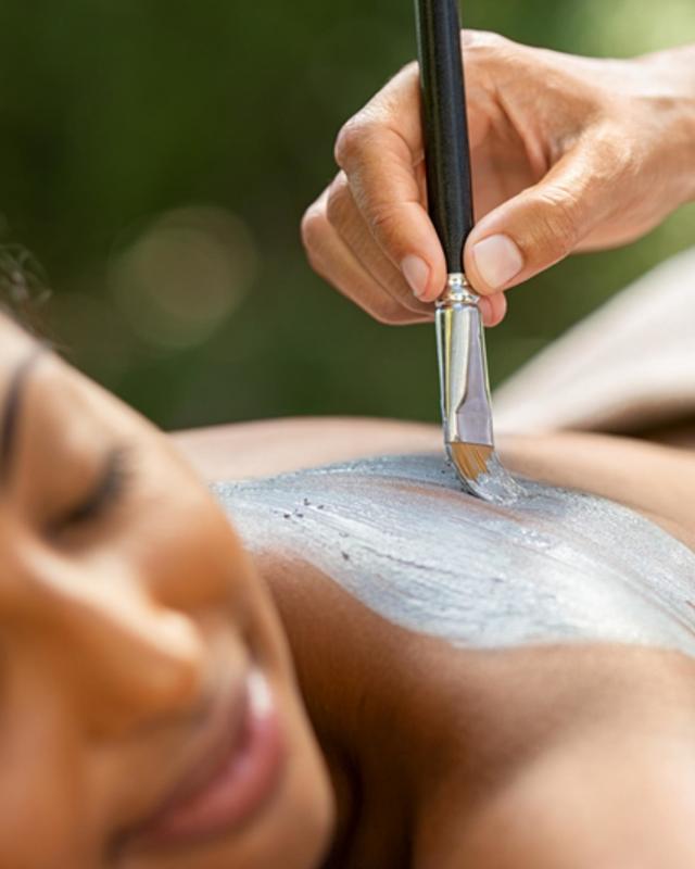 Woman getting an exfoliating mud body treatment at Canyon Ranch Fort Worth luxury spa. 