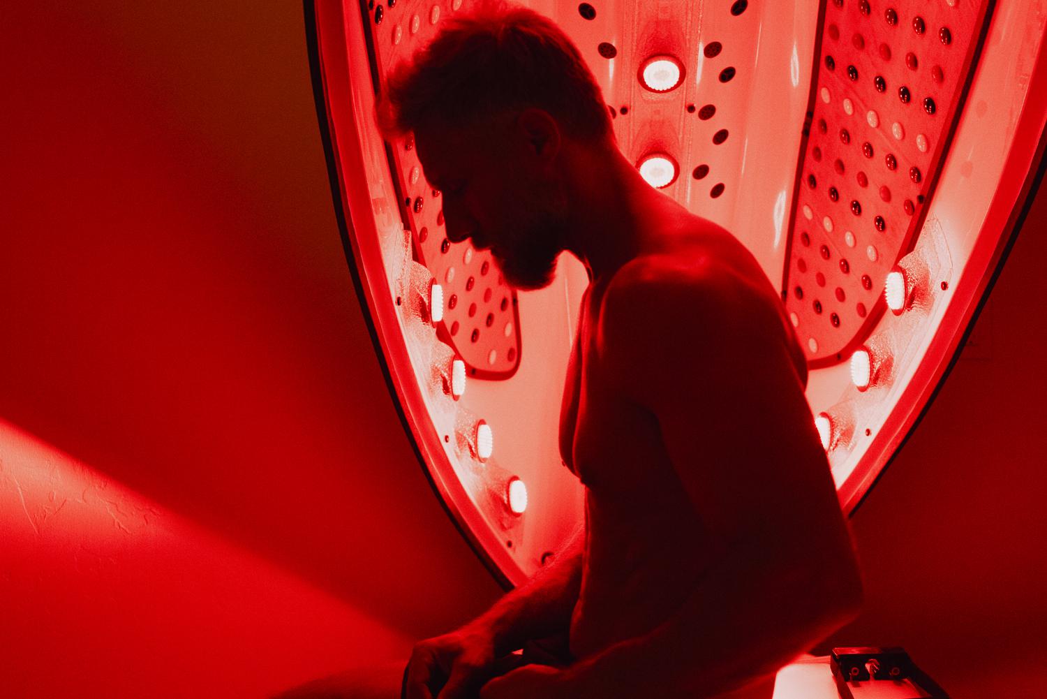 A man in an  infrared sauna pod