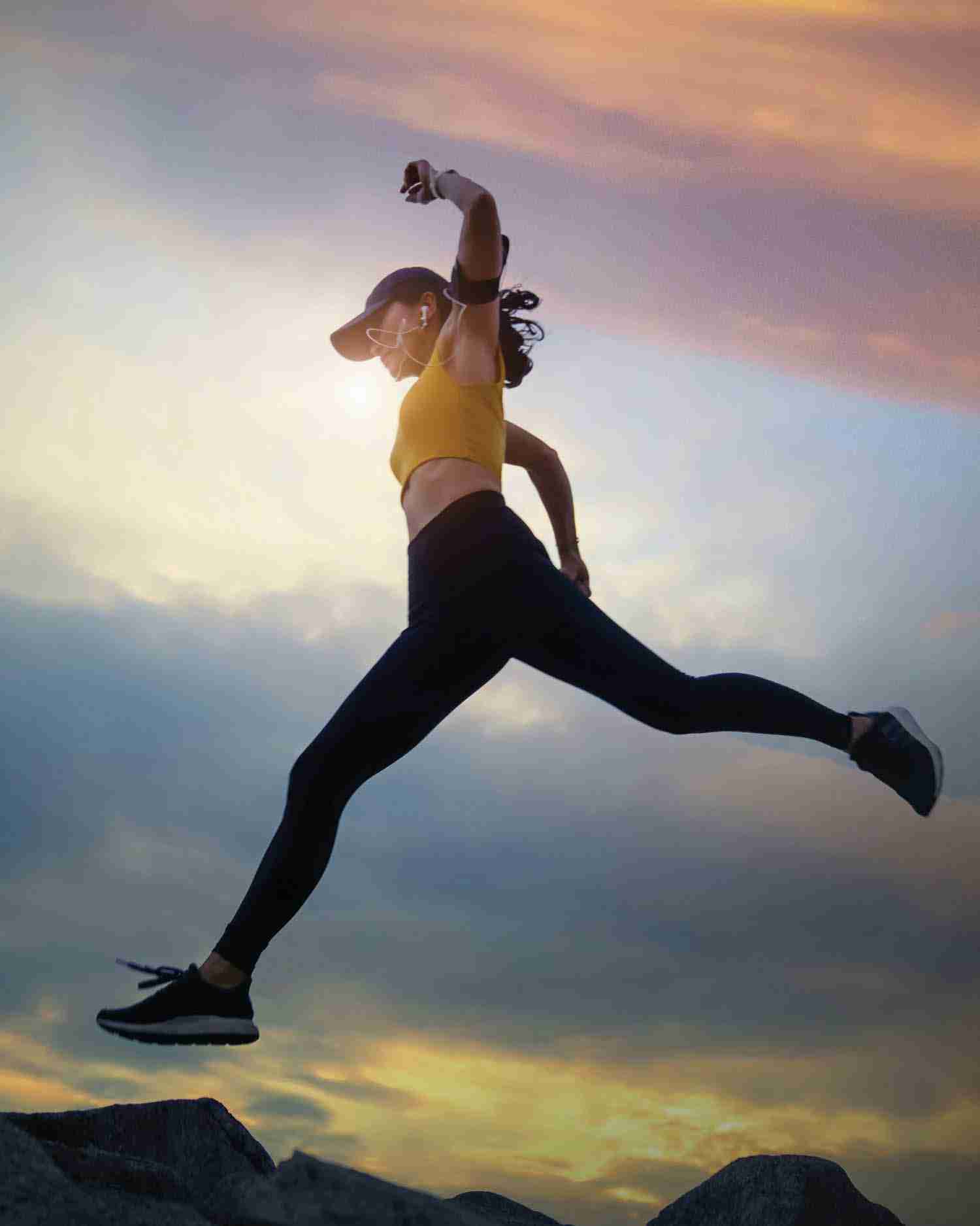 a woman jumping over a rock