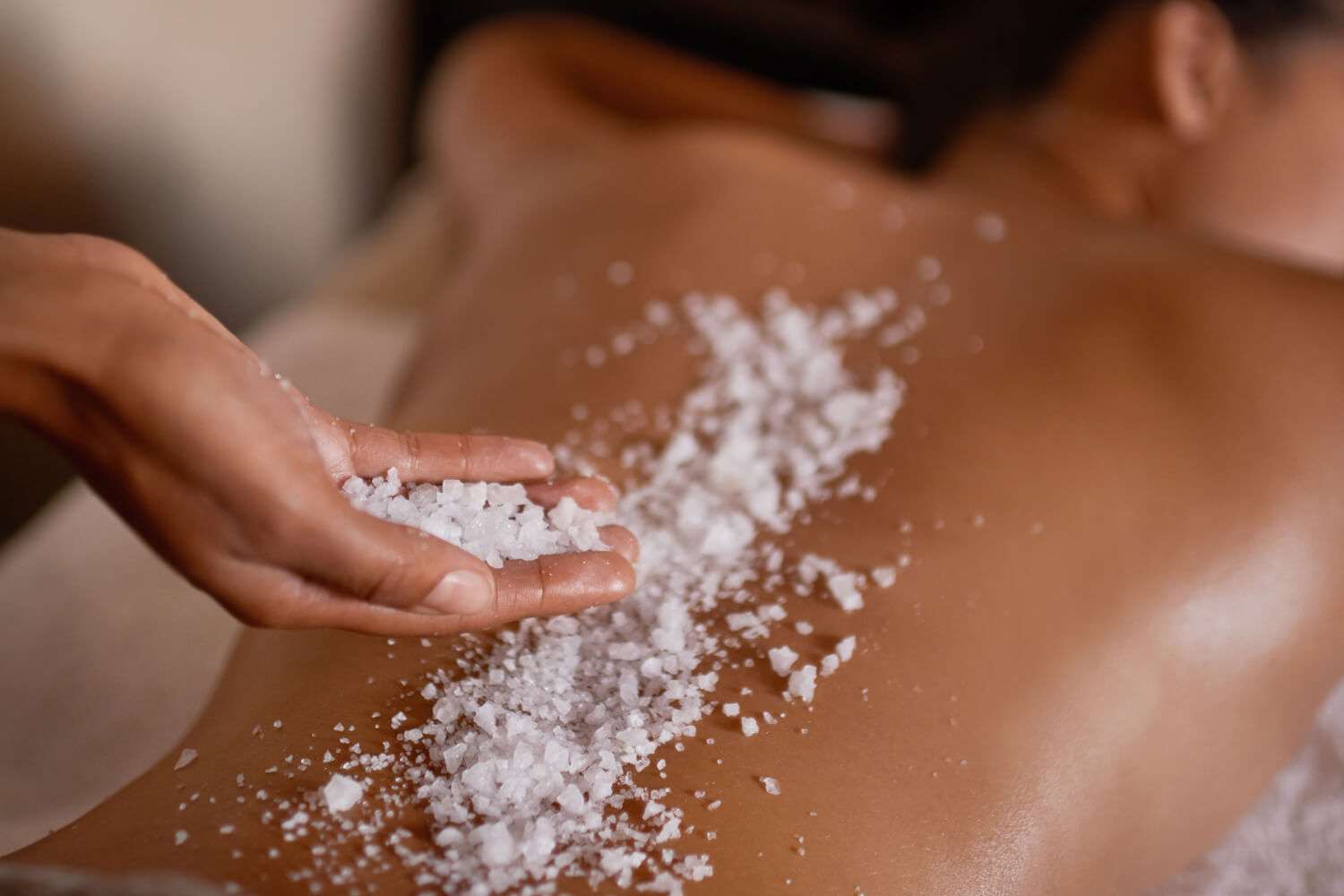 A woman getting a salt body scrub